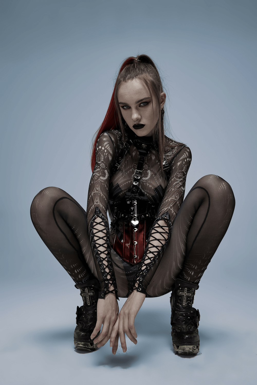 Model in edgy black mesh outfit with corset and Gothic style, showcasing an alternative fashion aesthetic.