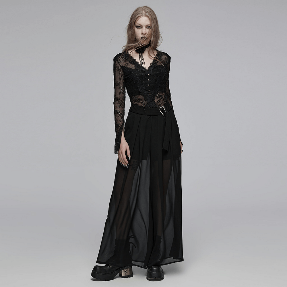 Edgy model in sheer black chiffon pants with buckle detailing, showcasing a punk rave aesthetic.