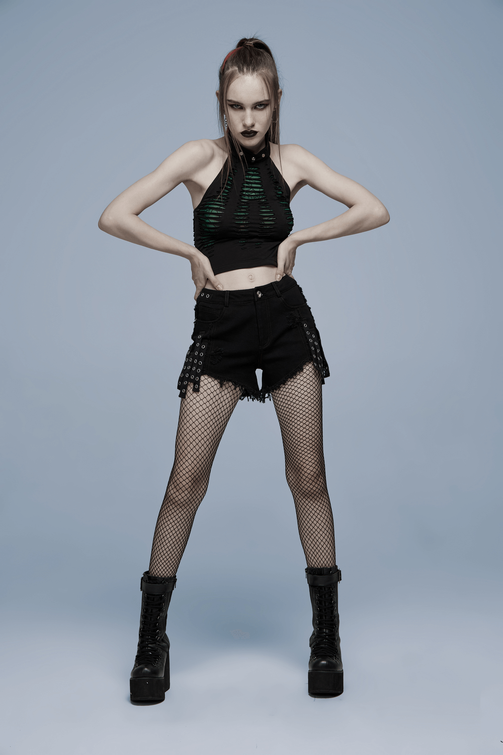 Black denim shorts with lace detailing, paired with a mesh top and fishnet stockings for a punk gothic look.