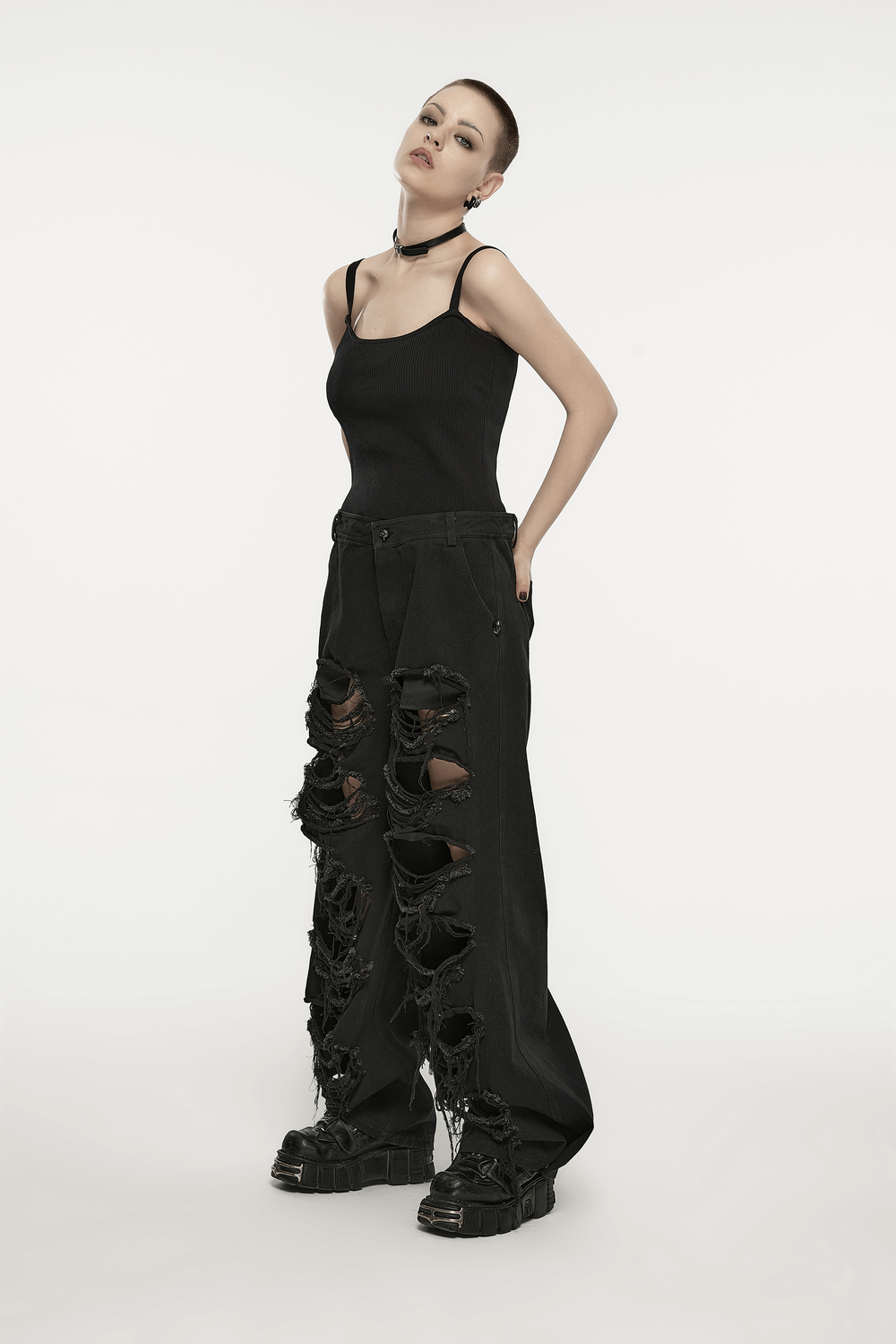Rockstar look featuring black distressed wide leg denim pants with rips, paired with a sleek black top and chunky boots.