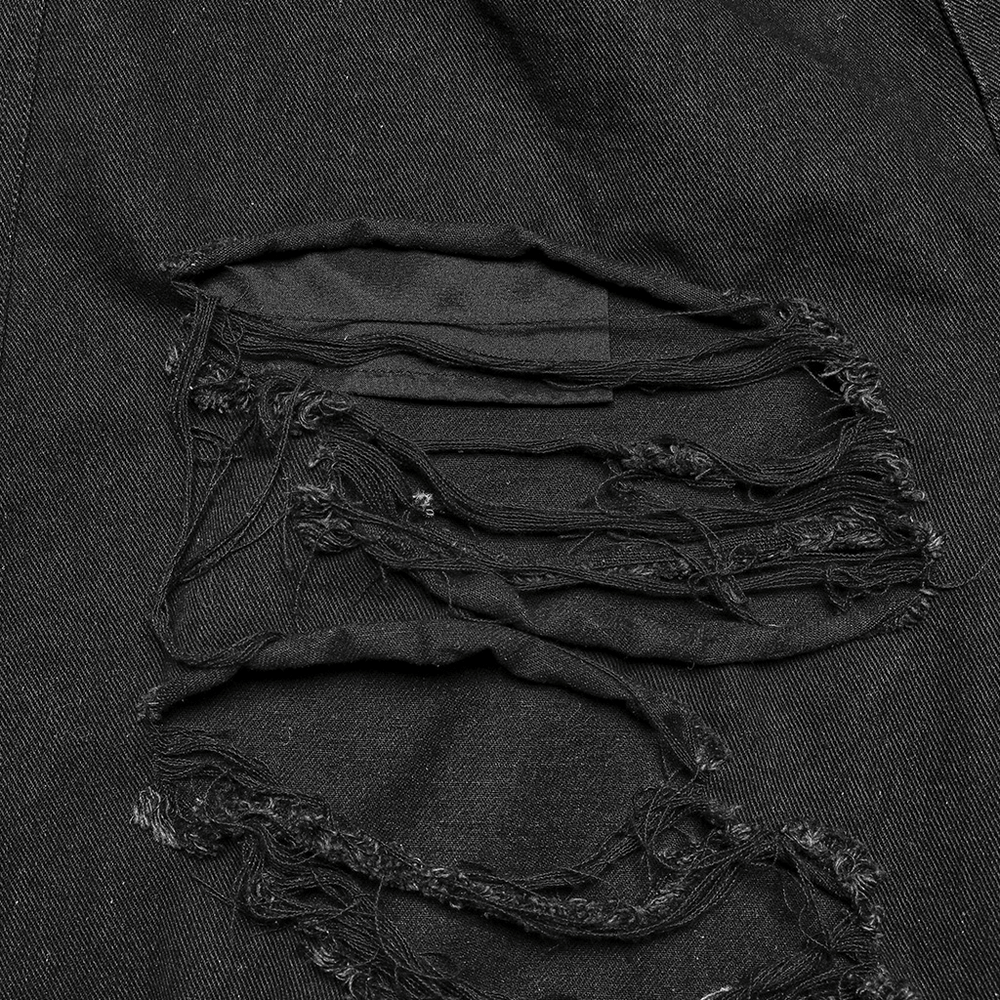 Close-up of distressed black denim fabric featuring ripped patches, perfect for punk-inspired fashion.