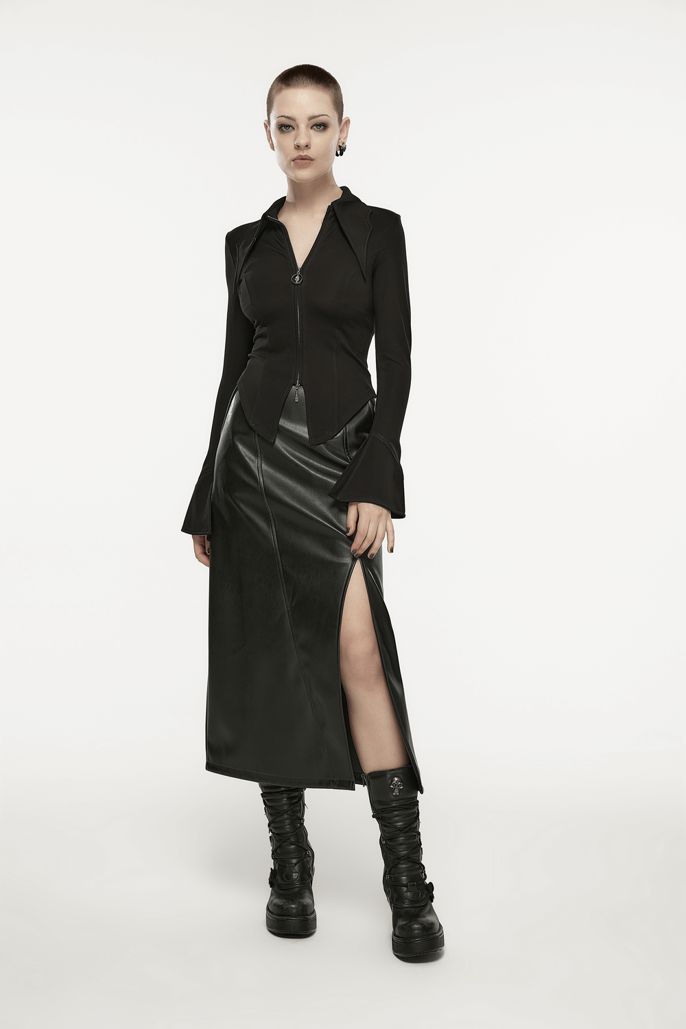 Model sporting a black faux leather high waist A-line skirt with a dramatic side slit, paired with a sleek zip-up top.