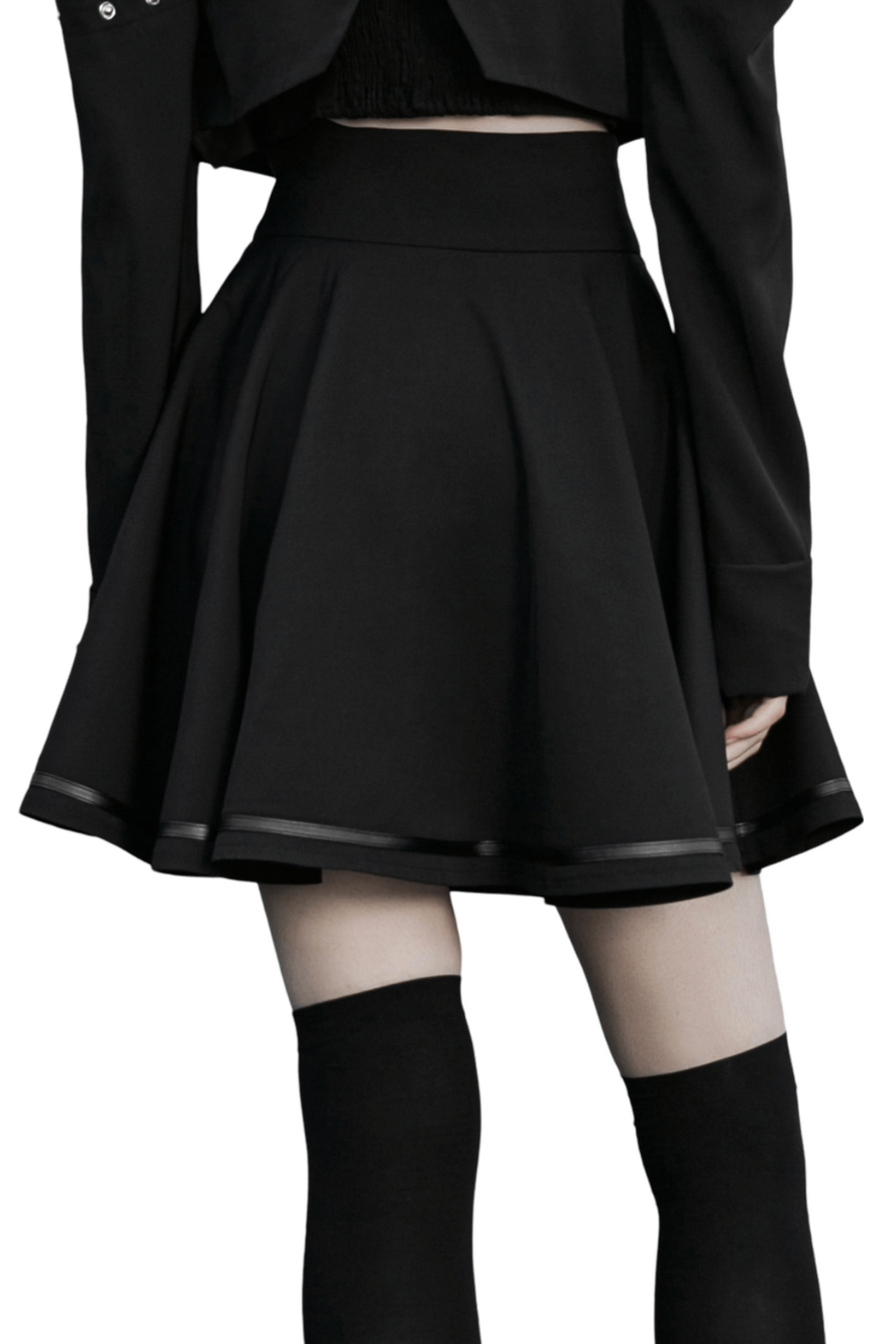 Back view of a sleek black high-waisted mini skirt with a pleated design and decorative buckle, styled for edgy fashion.
