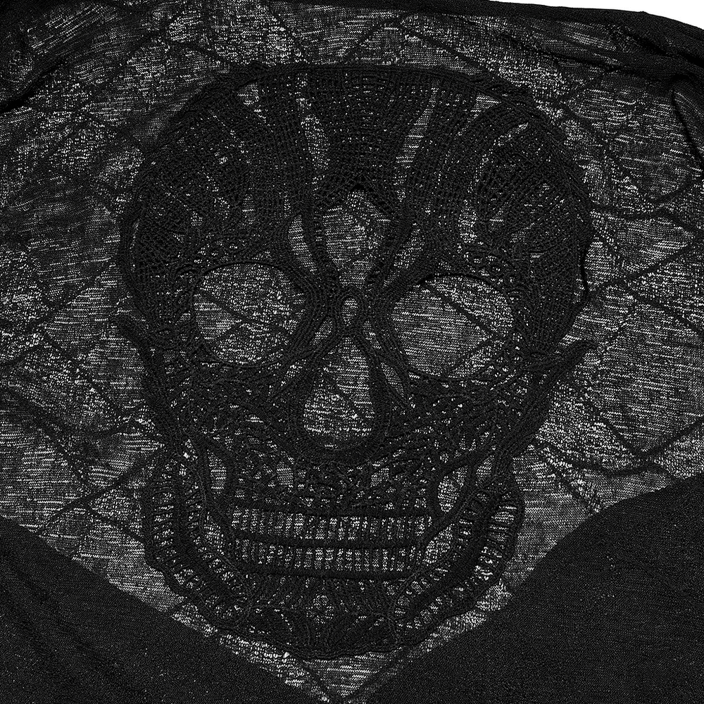Close-up of a textured black knit cardigan featuring a detailed skull lace patch.