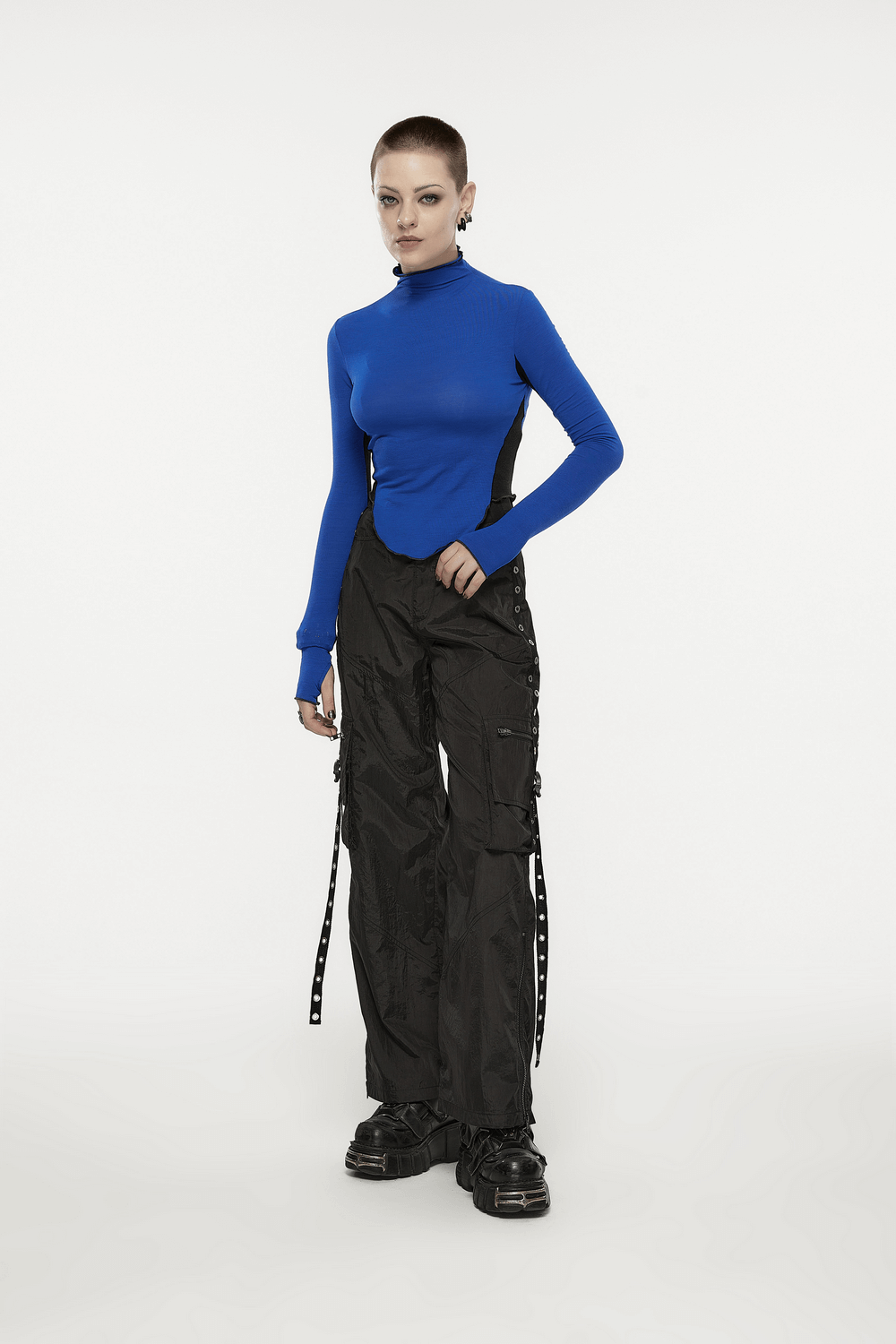 Model in blue top and black cargo pants with side chains showcasing urban streetwear style.