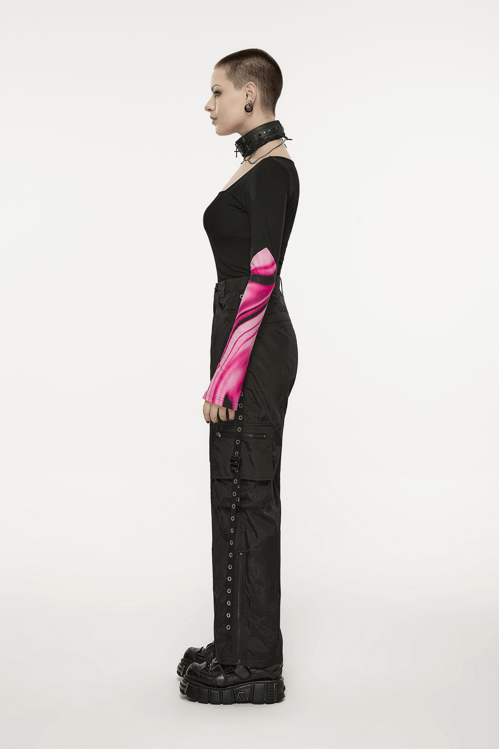 Side view of a model wearing black straight leg cargo pants with pink tie-dye sleeves and chunky boots.