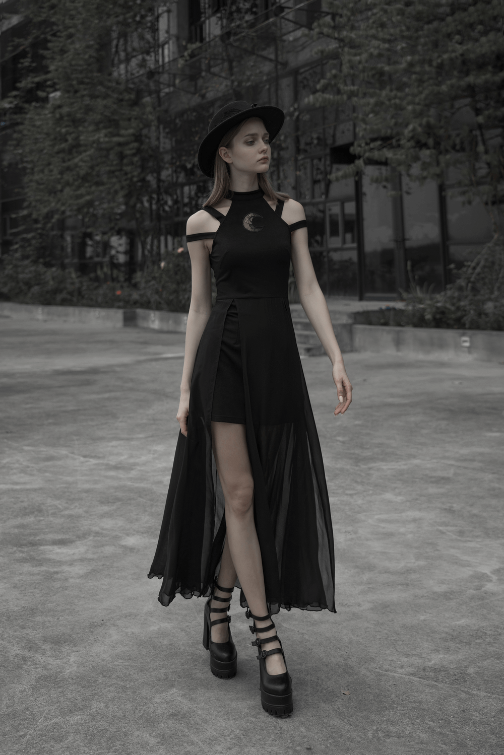 Model wearing a black Punk Rave gothic crescent moon dress with chiffon skirt and hat, showcasing dark elegance.