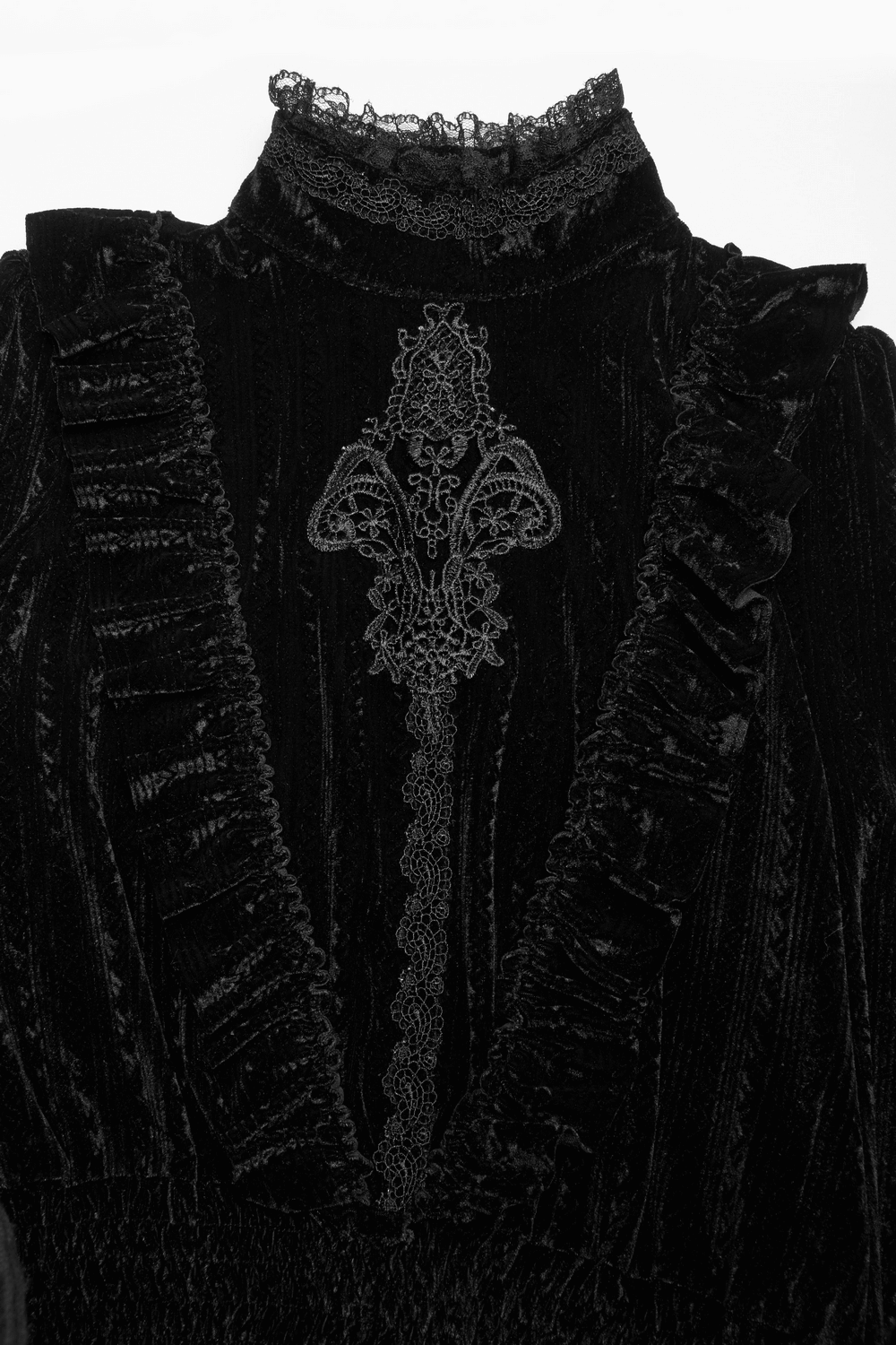 Elegant close-up of a black velvet blouse with ruffle collar and intricate embroidered detail.