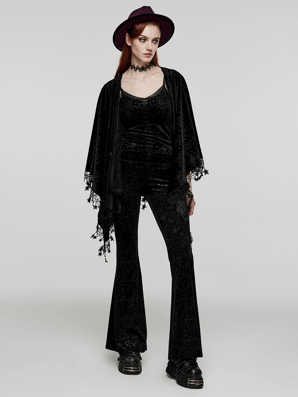 Women's gothic style model wearing a Punk Rave occult pentagram cape with velvet pants and a black hat.