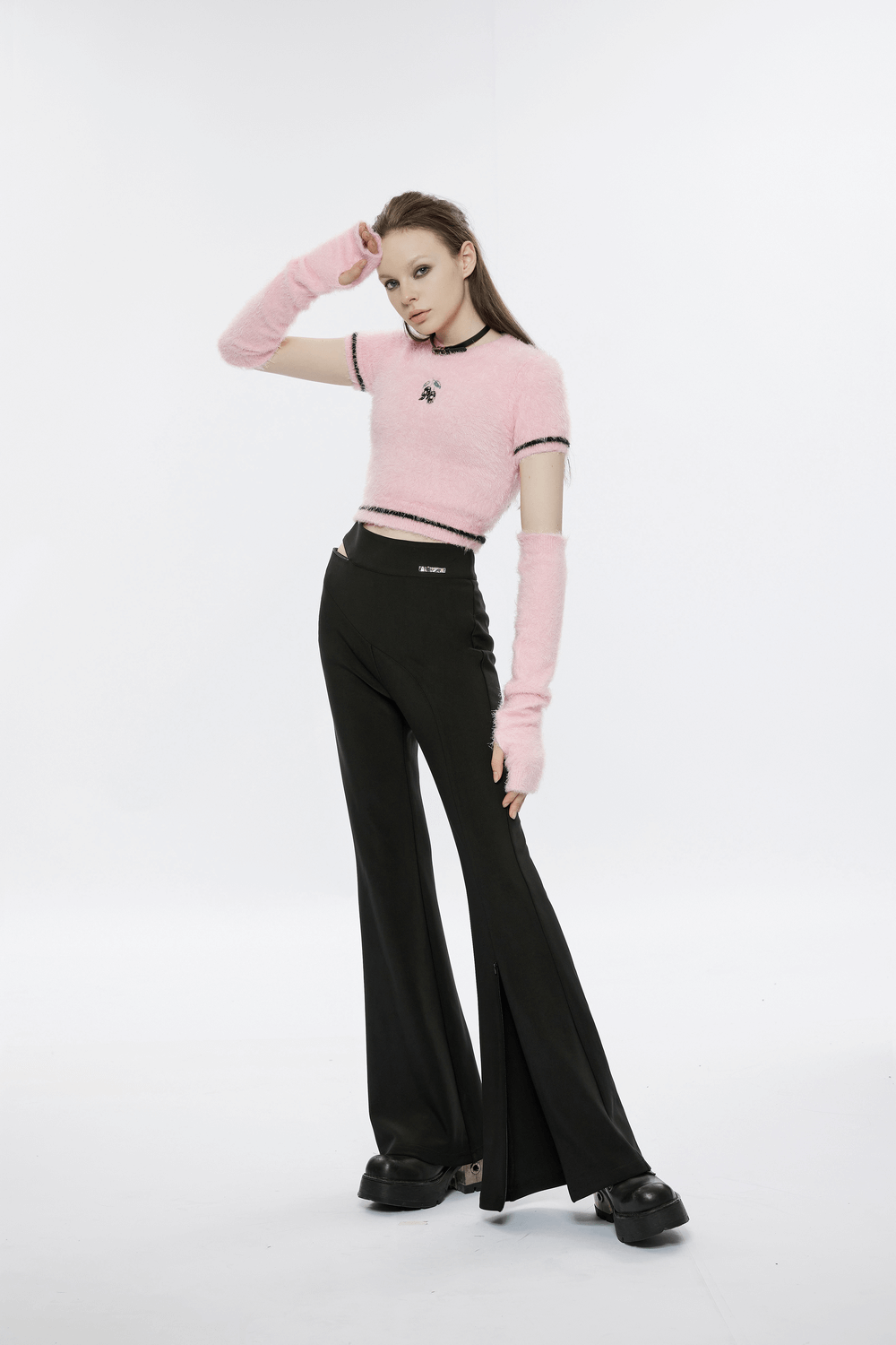 Model wearing Punk Rave pink faux fur crop sweater with cherry skull embroidery and black flared pants.
