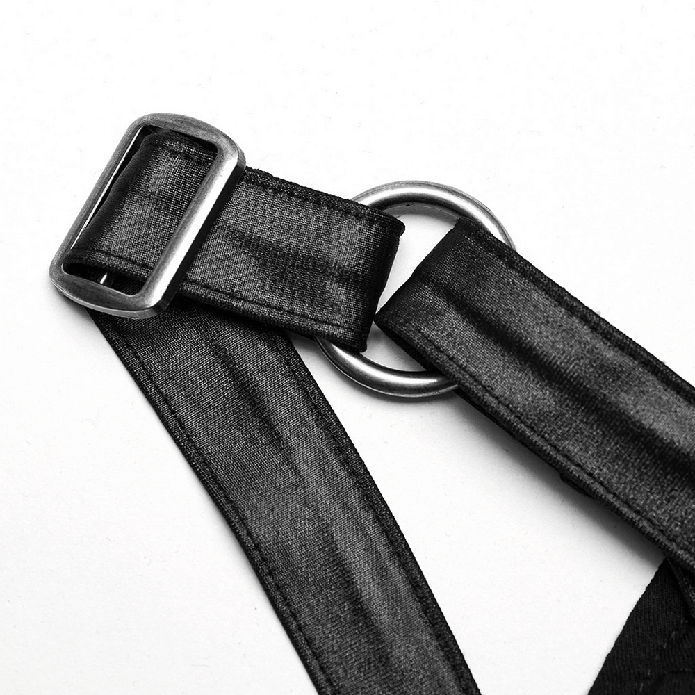 Close-up of black satin straps with silver buckles and rings, showcasing alternative fashion details.