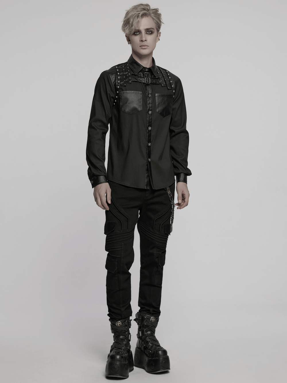 Punk riveted leather patchwork shirt showcasing a street style aesthetic on a model standing confidently.