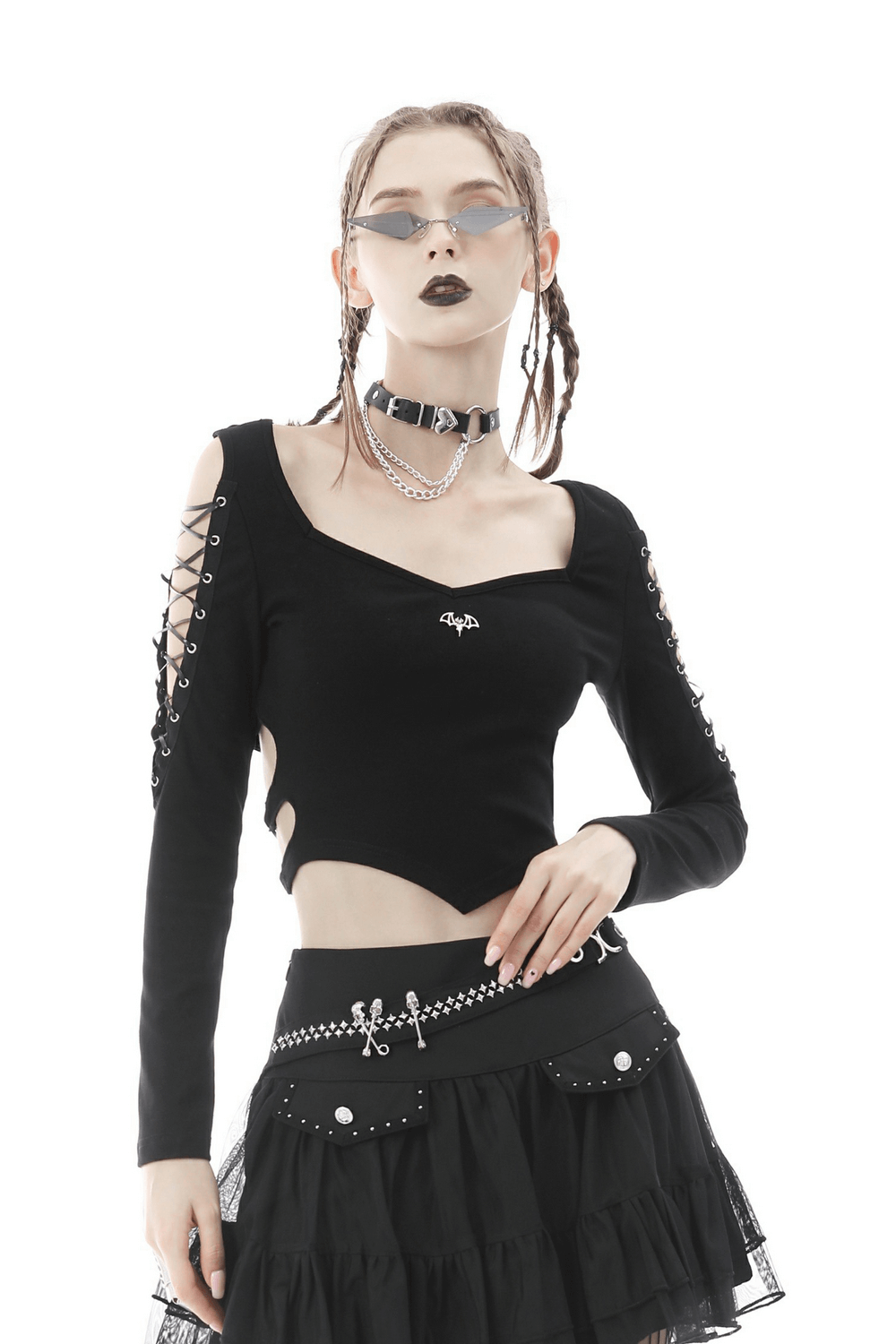Edgy punk rock batwing crop top with lace-up details, styled with a black skirt and accessories for a rebel vibe.