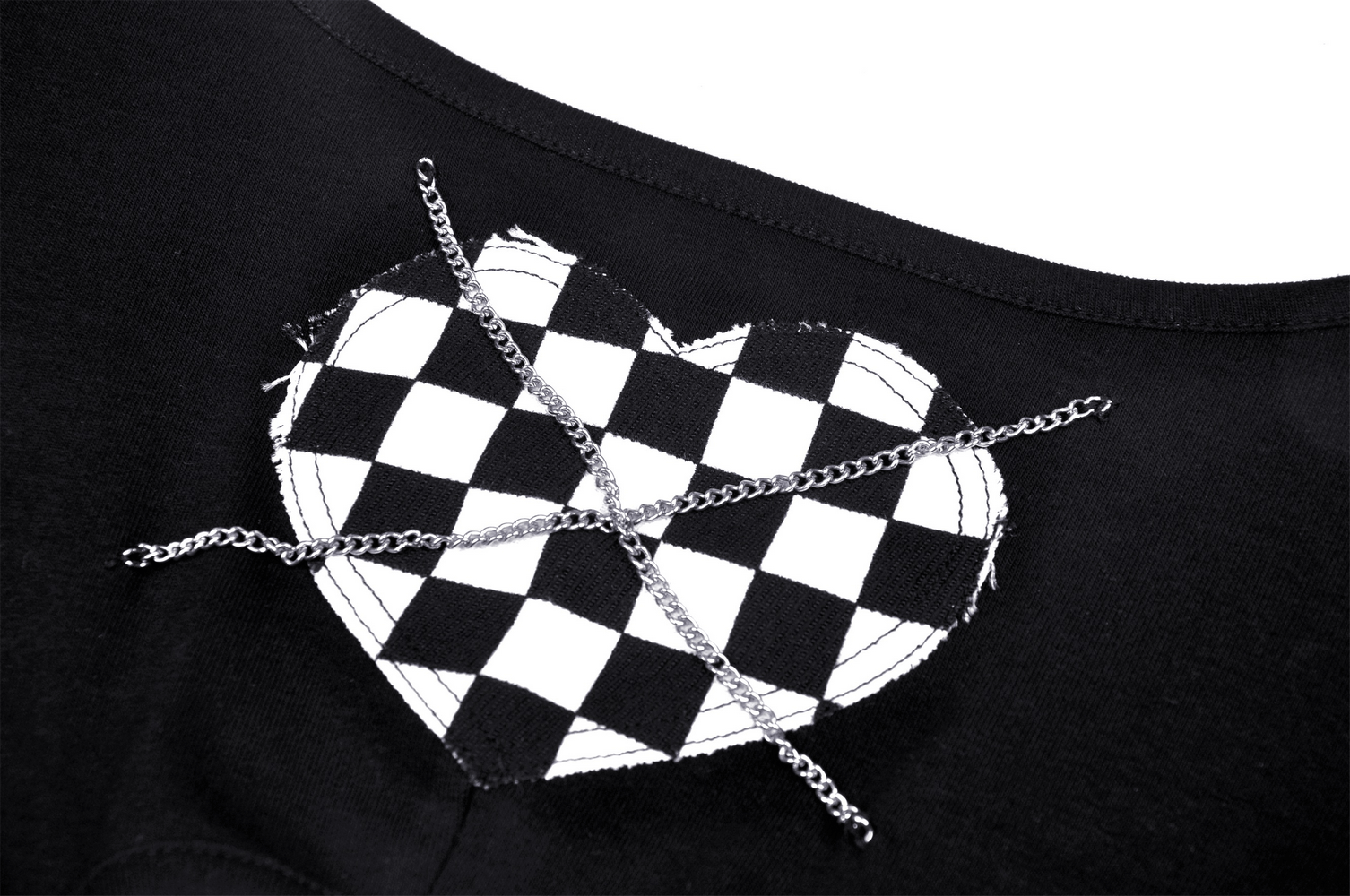 Close-up of a black crop top featuring checkered heart design with chain detail for an edgy punk rock style.