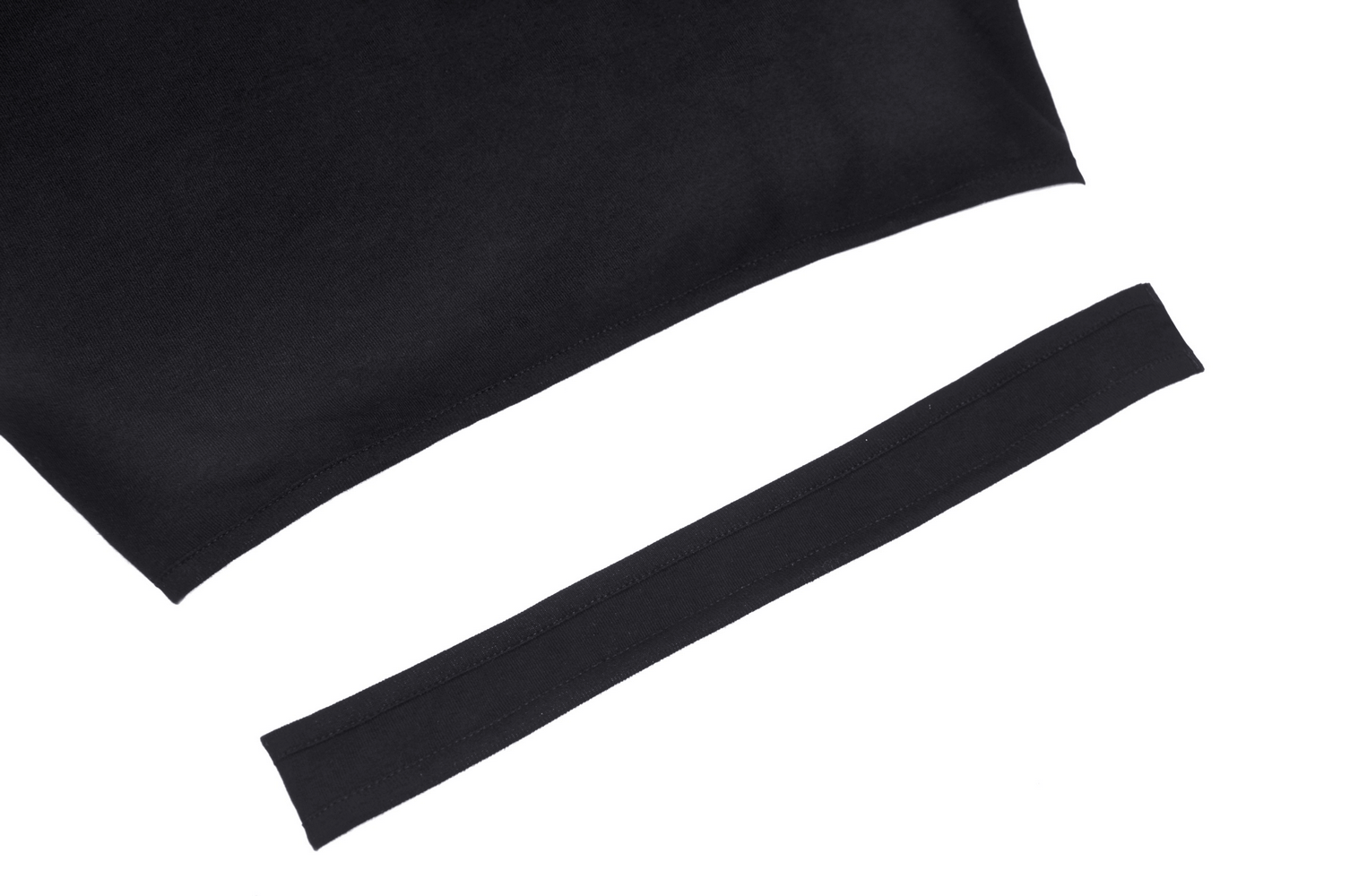Close-up of black crop top fabric with attached trim, showcasing soft and stretchy material for edgy punk styles.