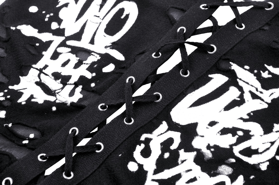 Close-up of black lace-up crop top showcasing edgy graphic prints and distressed fabric details.