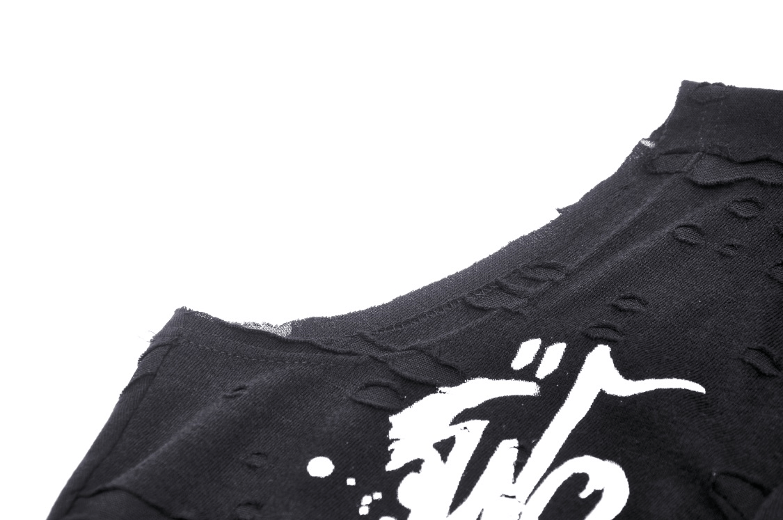 Edgy black crop top detail with distressed fabric and bold white graphic design for a punk rock look.