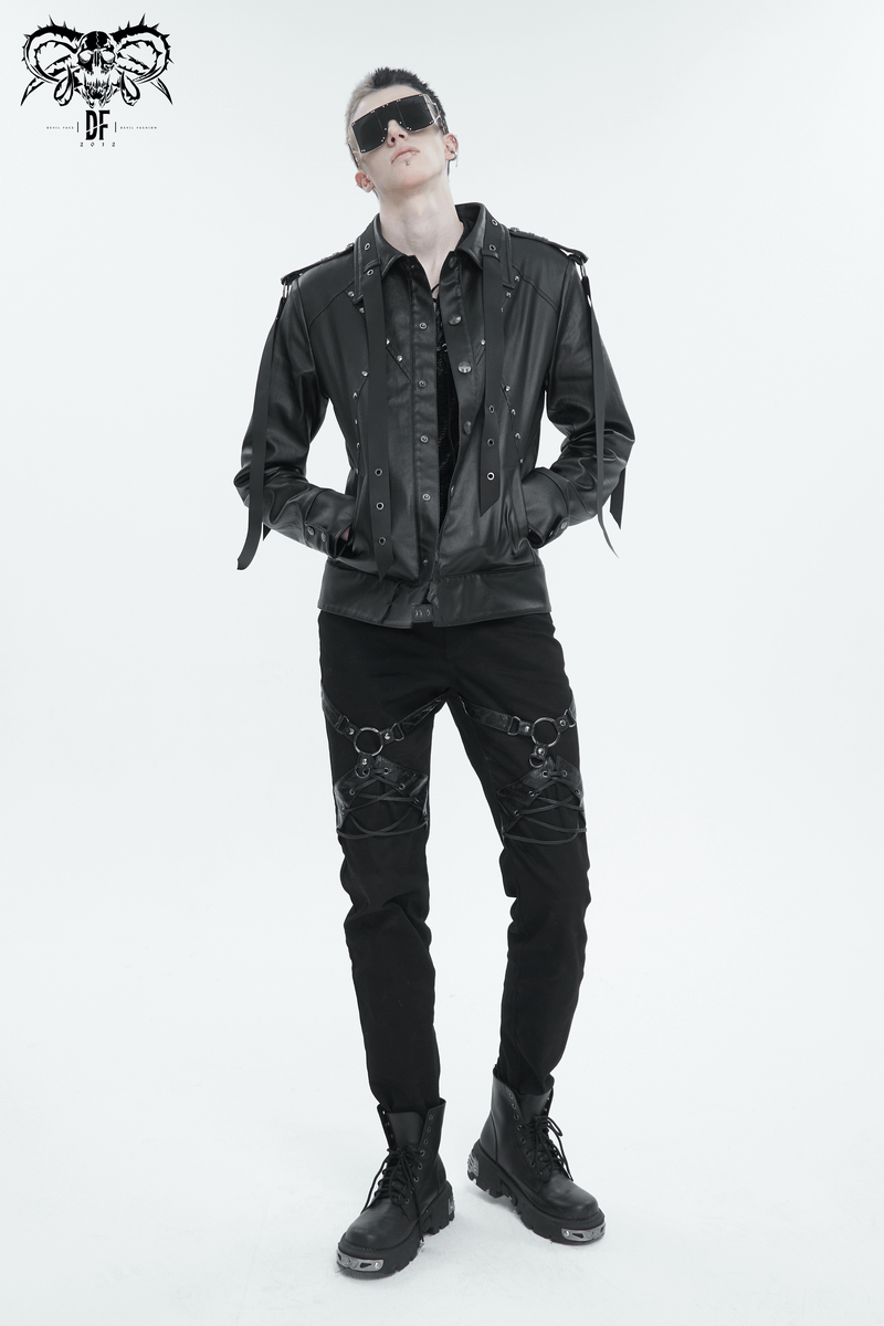 Fashionable man in punk rock attire wearing a leather jacket and fitted black trousers with edgy details.