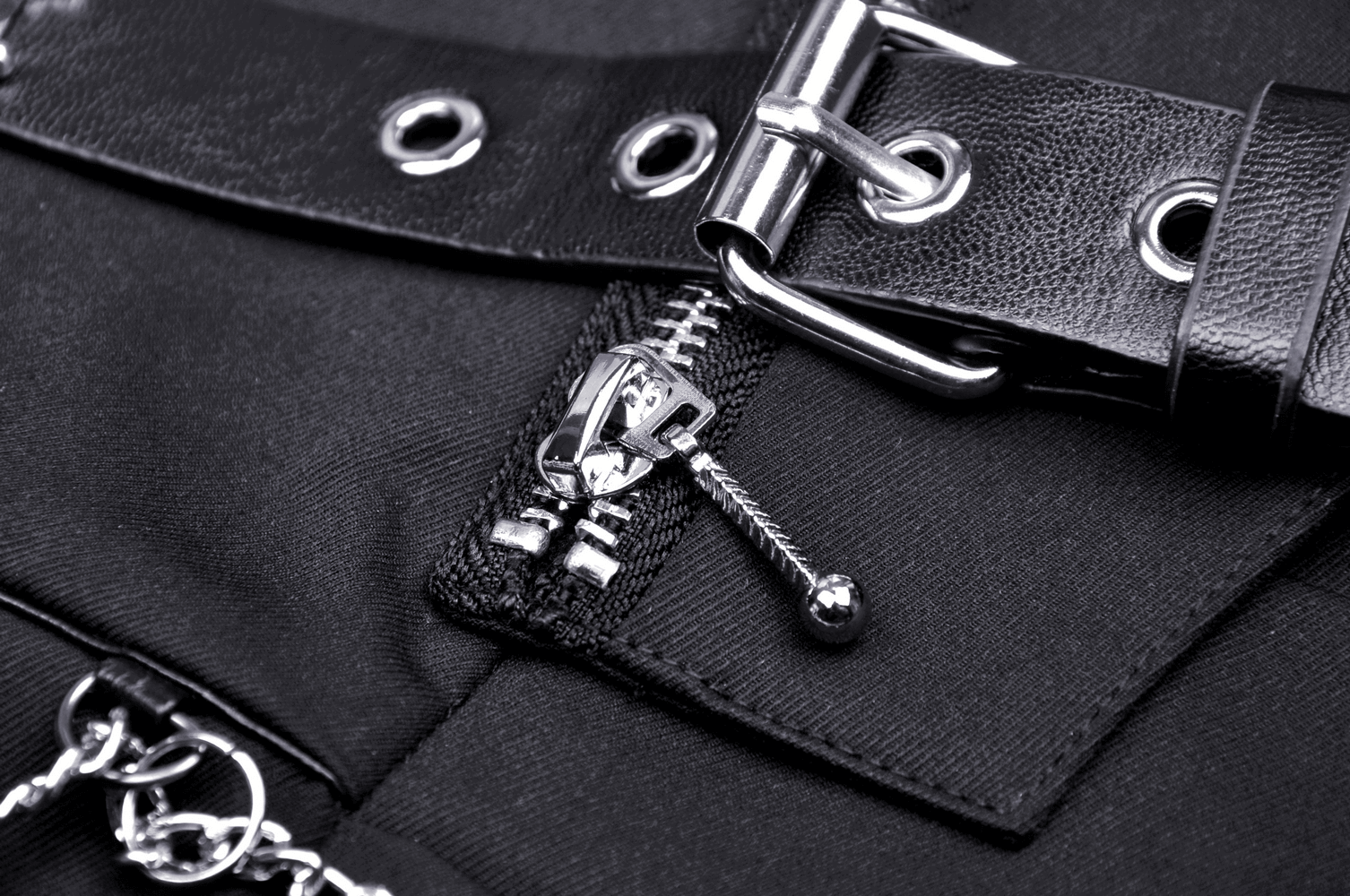 Close-up of black punk rock pleated mini skirt with chain, featuring a zipper and buckle details.