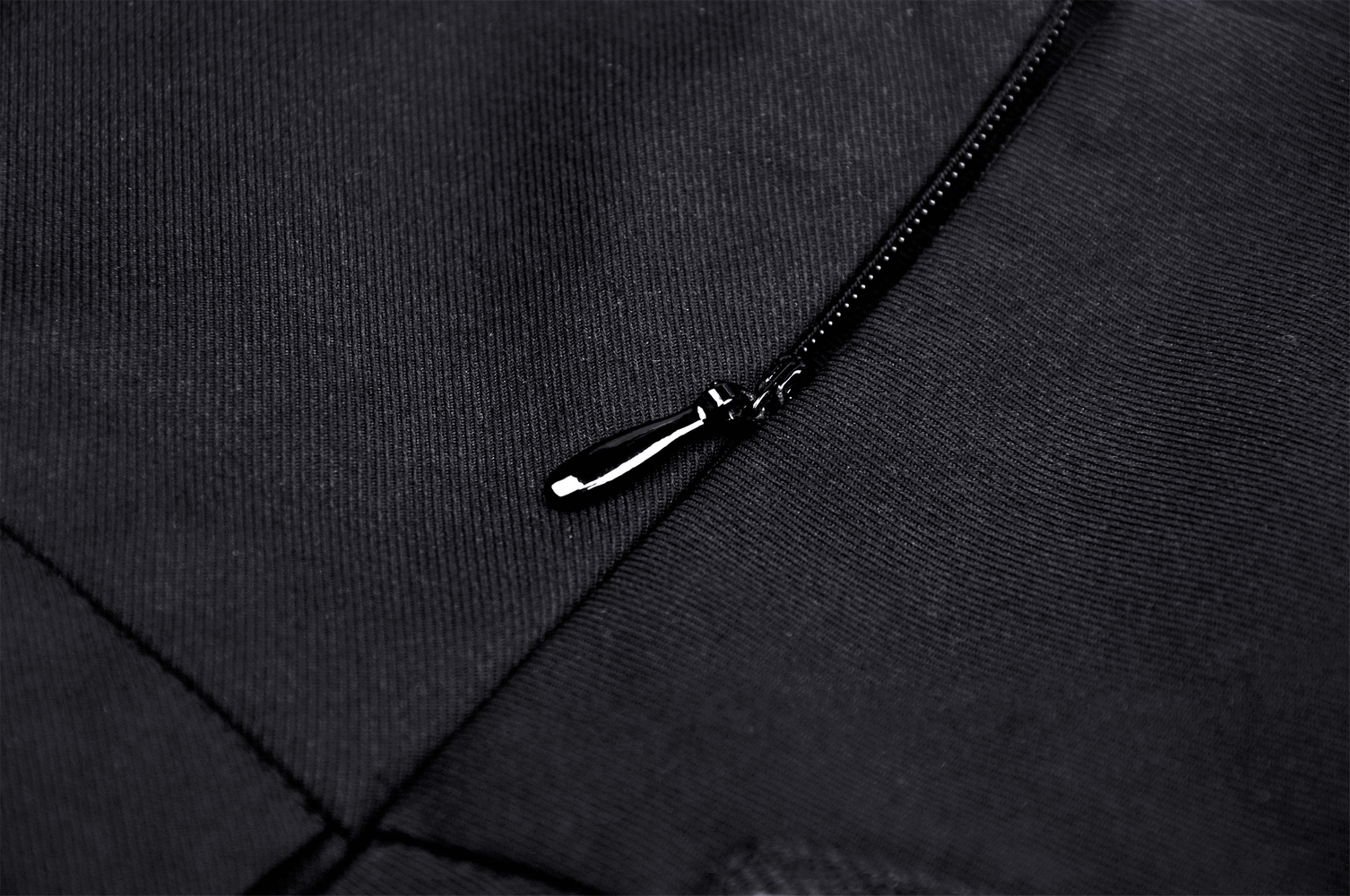 Close-up of a black zipper on fabric, showcasing a sleek and stylish design for edgy fashion items.