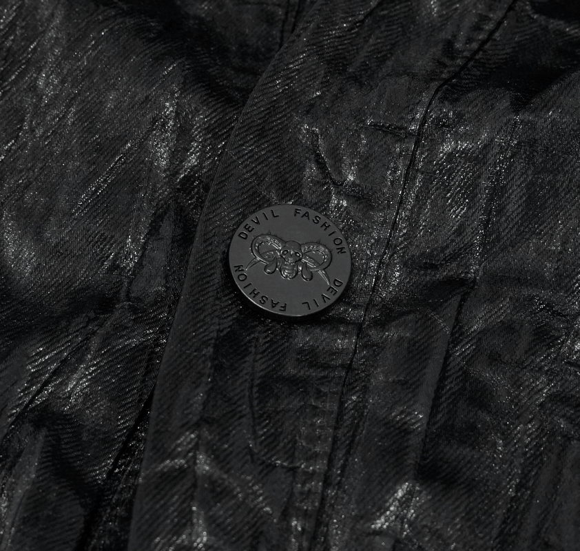 Close-up of black fabric with a stylish Devil Fashion button, showcasing punk rock style details.