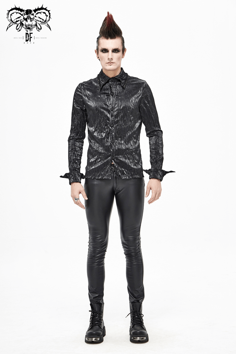Stylish male model wearing a punk rock black long-sleeved shirt with leather pants and edgy hairstyle.