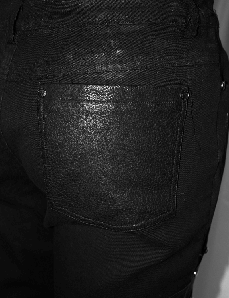 Close-up of side pocket on men's black punk rock trousers with silver studs and leather detailing.