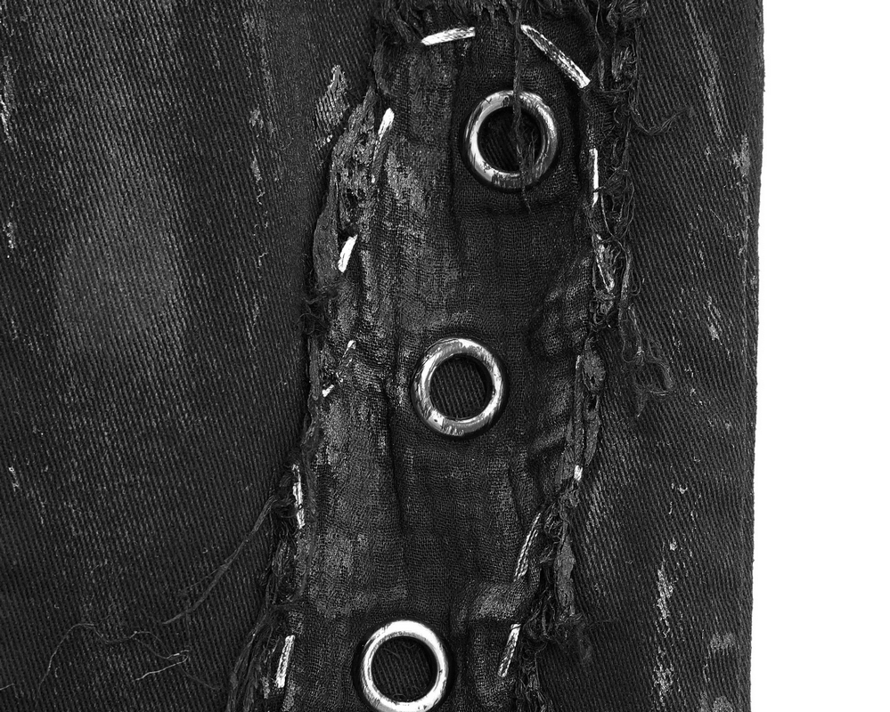 Close-up of punk rock trousers showing silver rivets and distressed fabric detail.