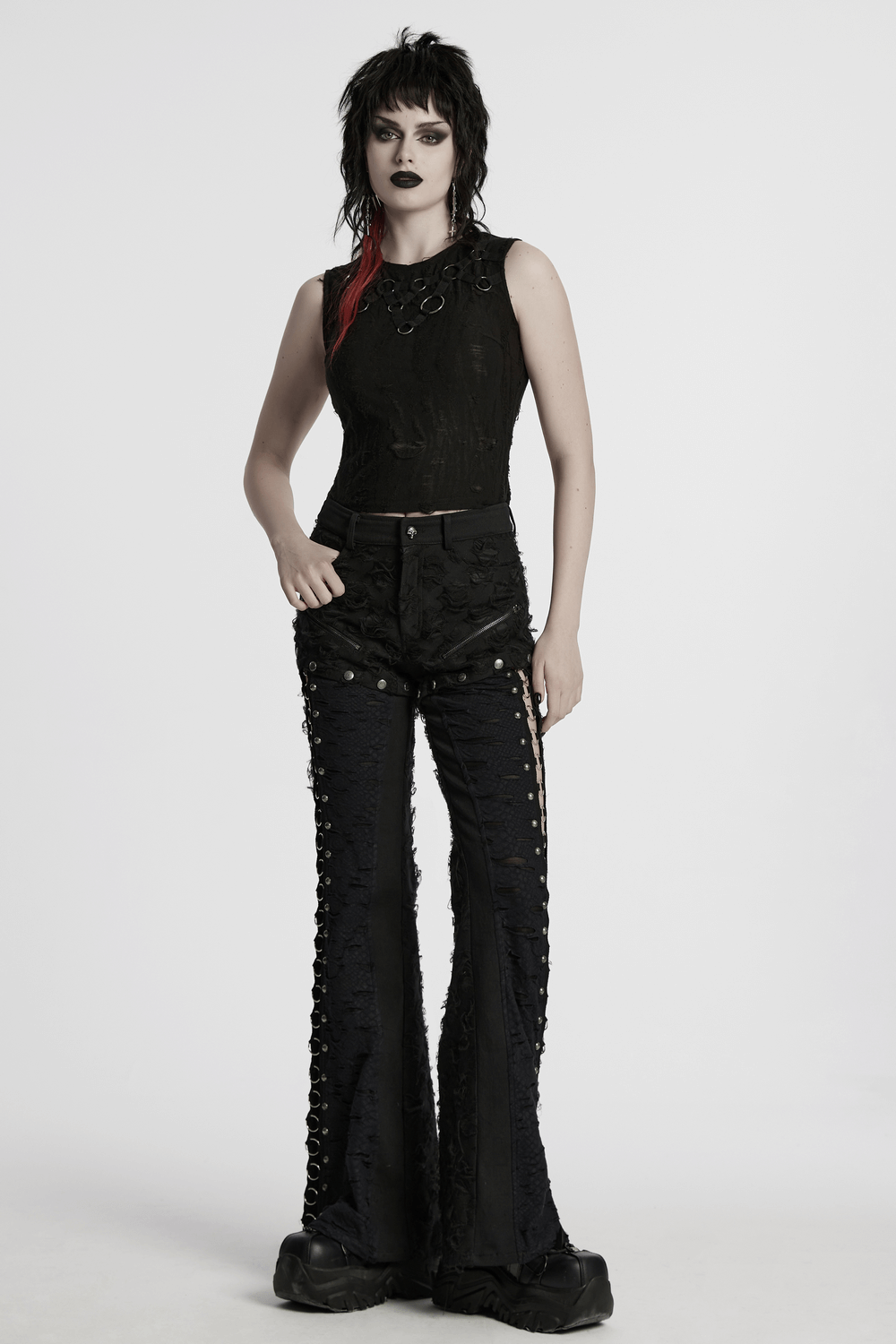 Punk rose-embellished split wide leg tattered pants with iron ring detailing styled with a sleek top and edgy makeup.