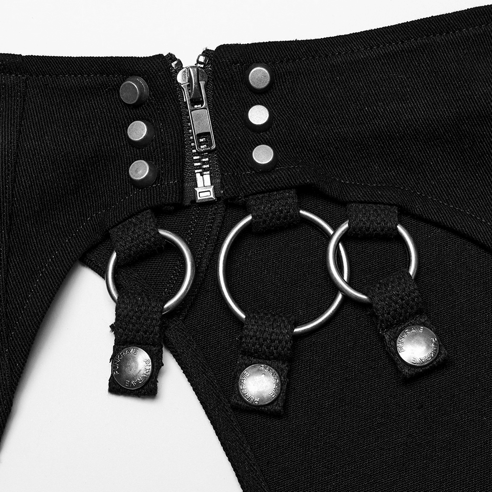Close-up of punk-inspired black fabric with metal ring details and stylish snap buttons, perfect for an edgy look.