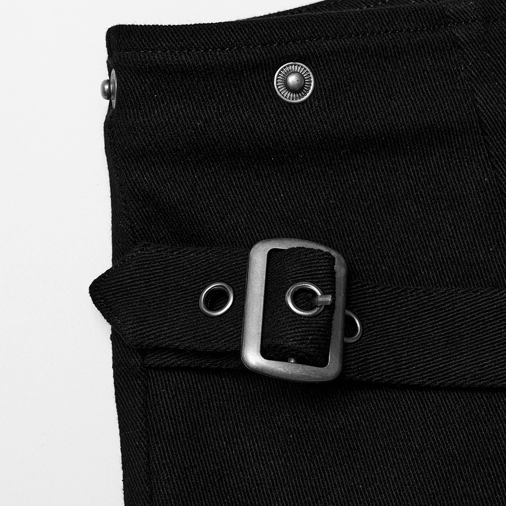 Close-up of black fabric featuring a metal buckle and rivets, adding punk flair to stylish shorts.
