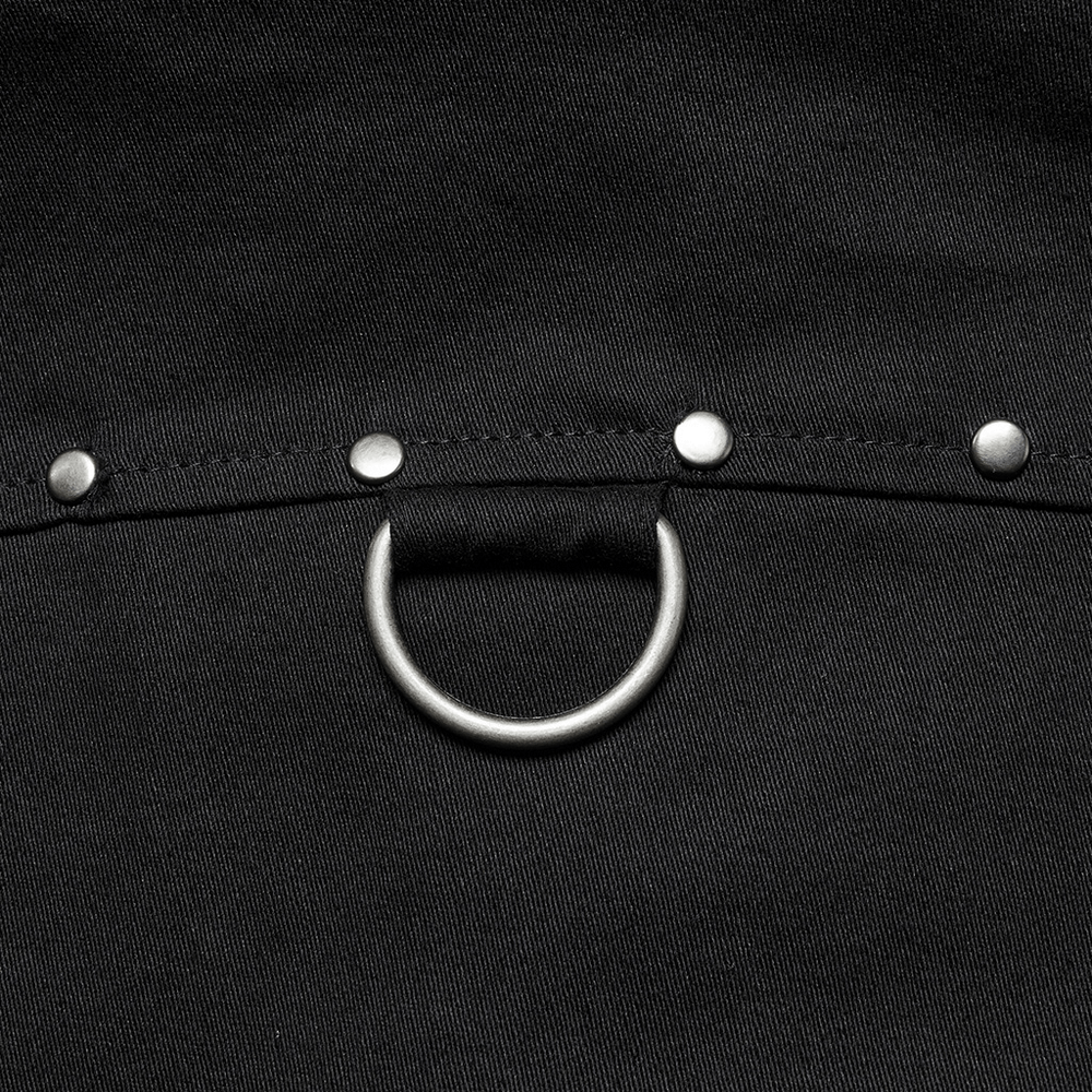 Close-up of black twill fabric featuring silver studs and a circular ring detail for a punk-inspired look.