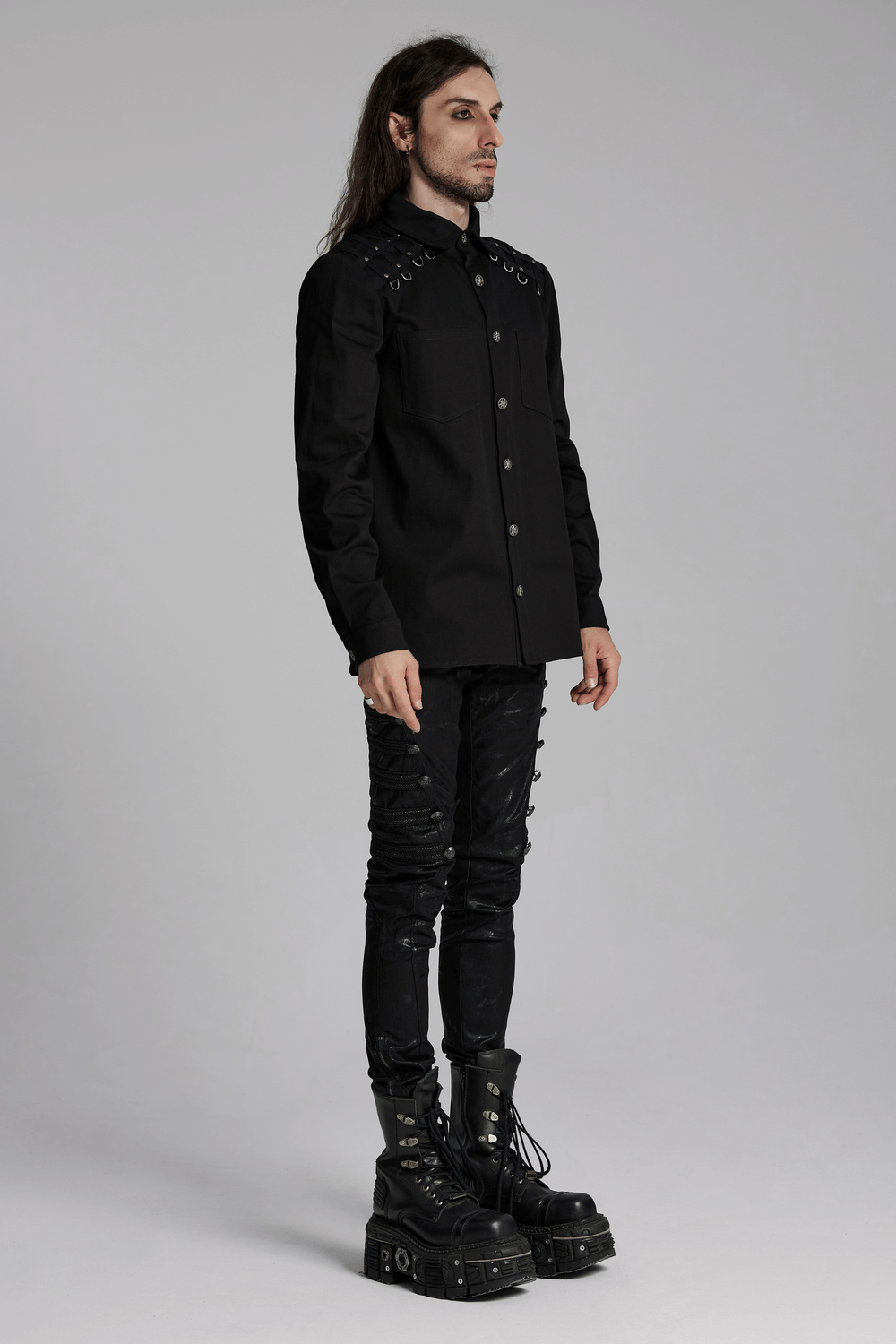 Stylish men's punk-inspired shirt in black twill with studded shoulders, paired with edgy black pants and chunky boots.