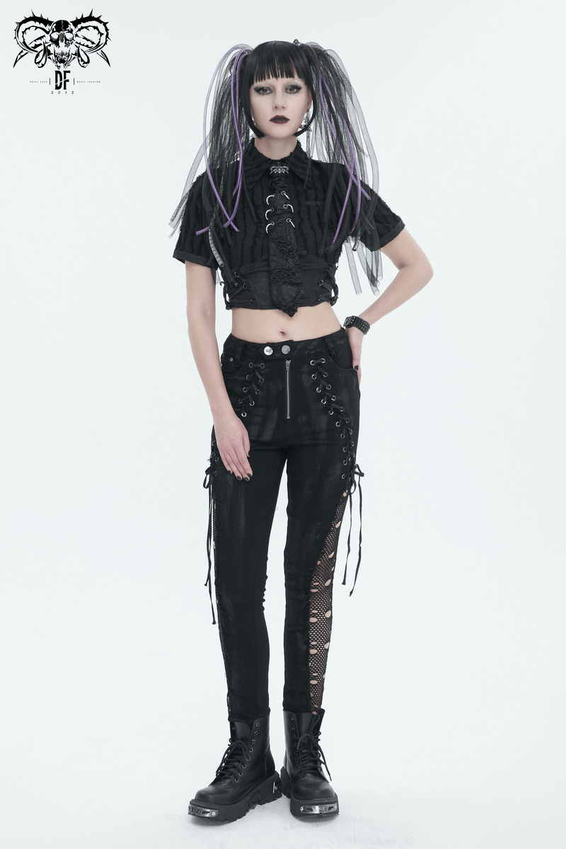 Stylish gothic model in punk outfit with lace-up pants and cropped top, showcasing alternative fashion aesthetics.
