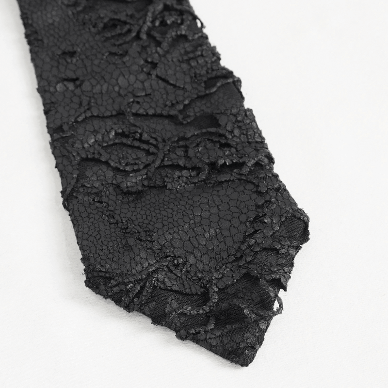 Close-up of a punk skull necktie with textured black fabric featuring gothic rose patterns.