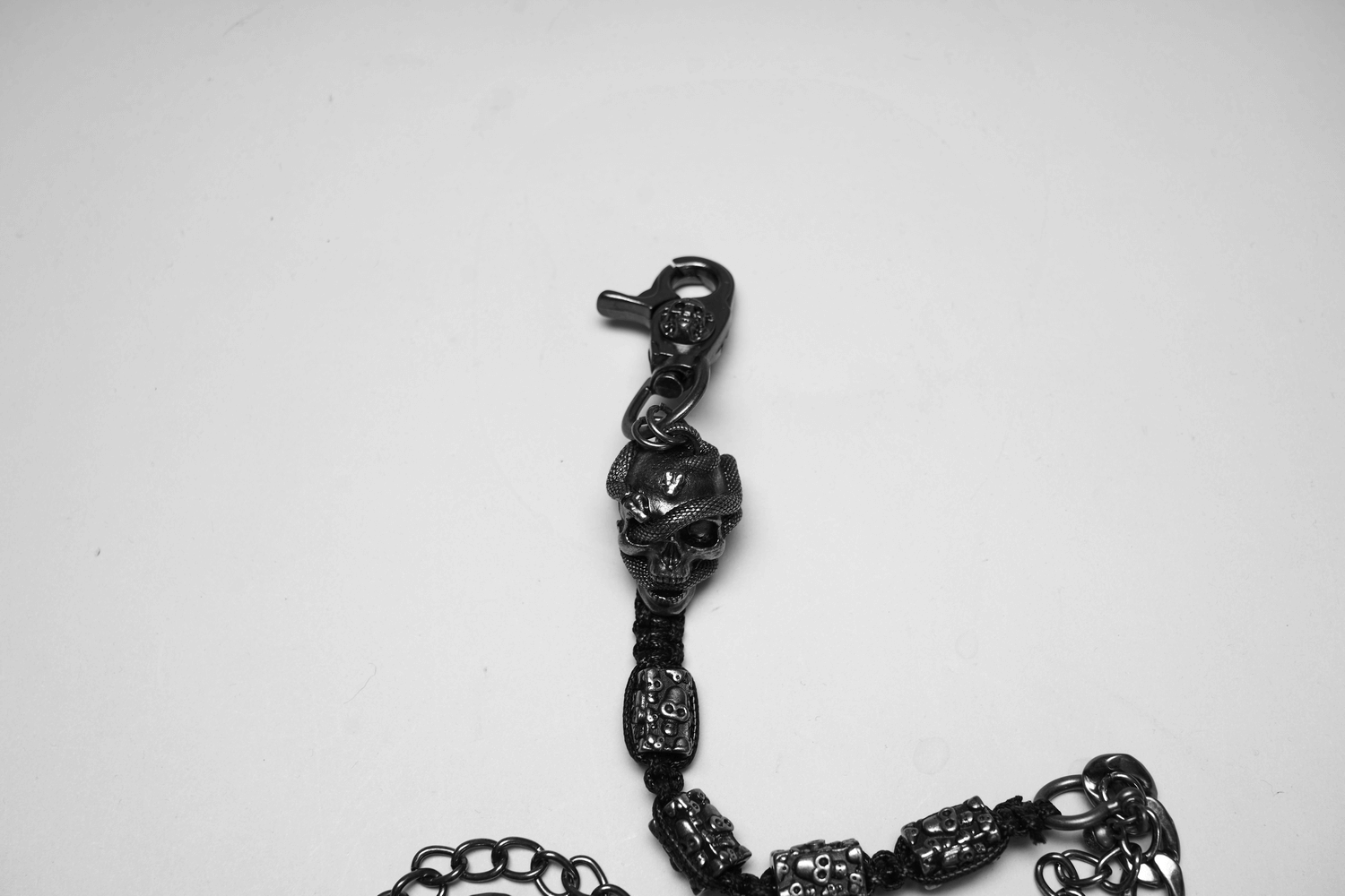 Close-up of punk skull snake pant chain with metal clasp and detailed skull design.