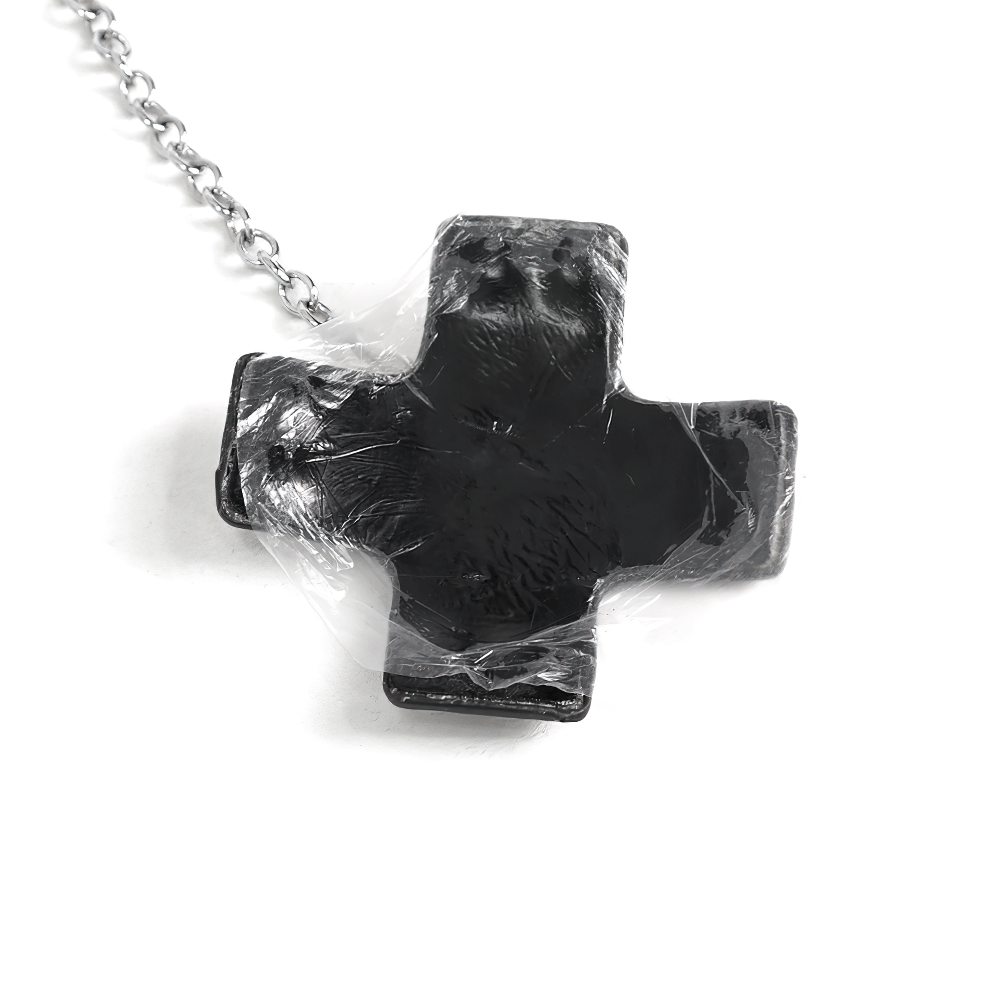Black cross-shaped nipple cover with a chain, perfect for punk fashion and bold accessories.