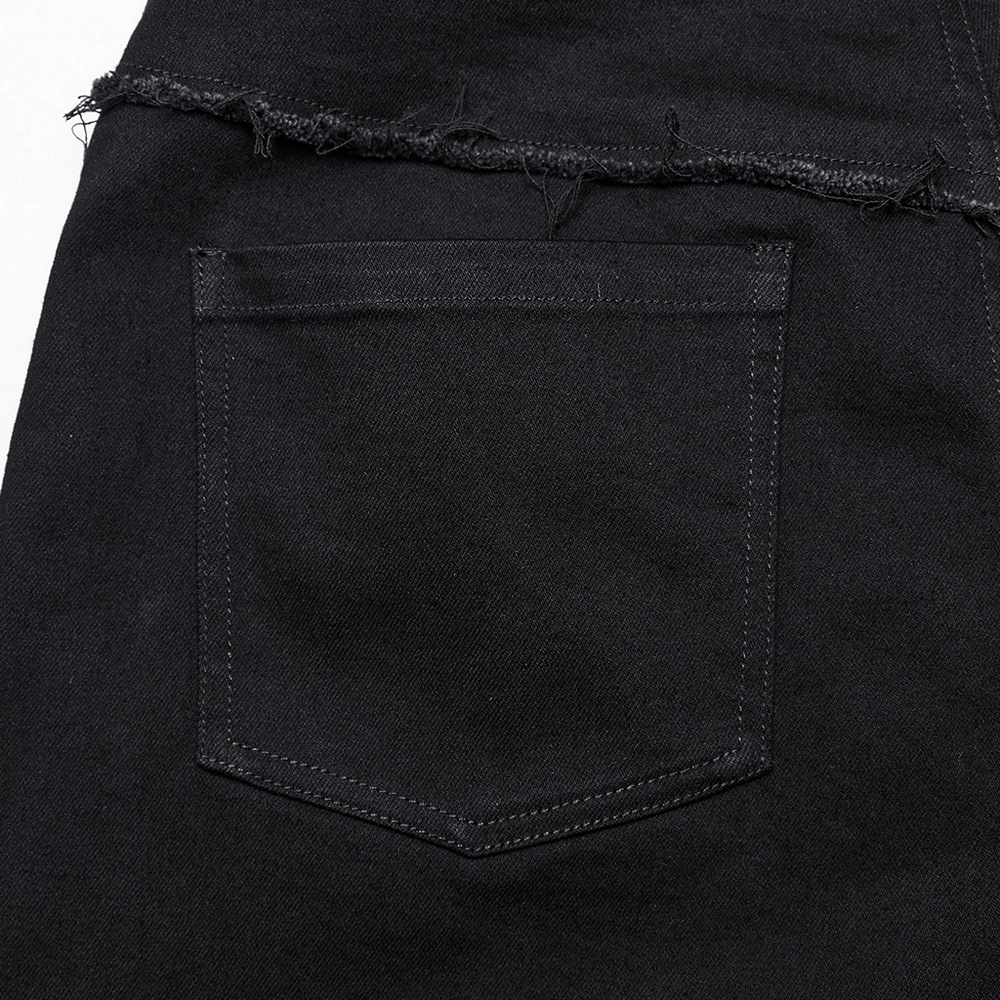 Close-up of a back pocket on black punk straight-leg denim pants with distressed edges.