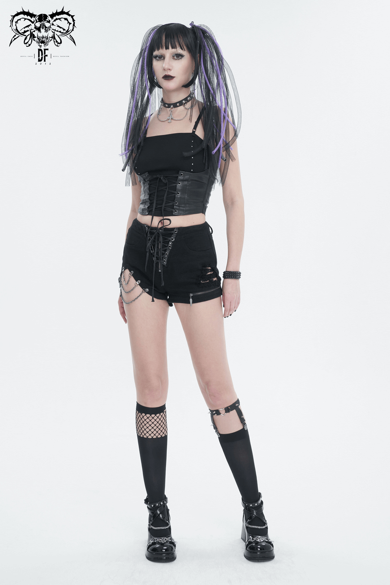 Punk woman in black gothic outfit with lace-up top and shorts, showcasing alternative fashion style.