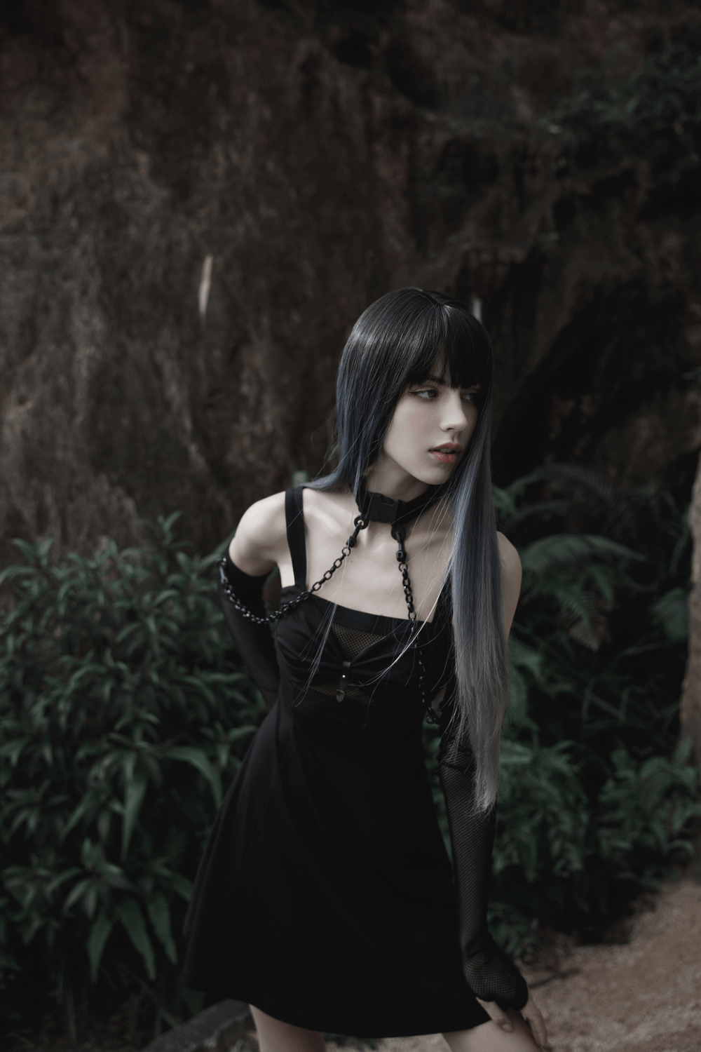 Punk style model wearing a black gauze choker and detachable arm sleeves in a forest setting.