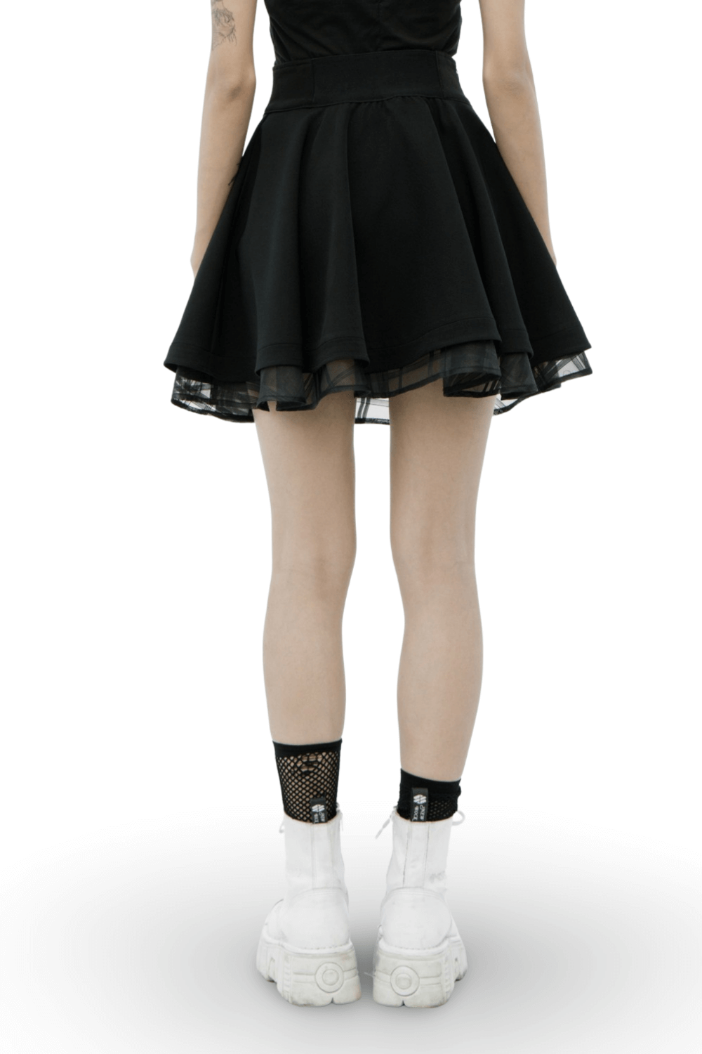 Back view of a black high waist layered skirt, paired with stylish white boots and fishnet socks, showcasing a punk fashion aesthetic.