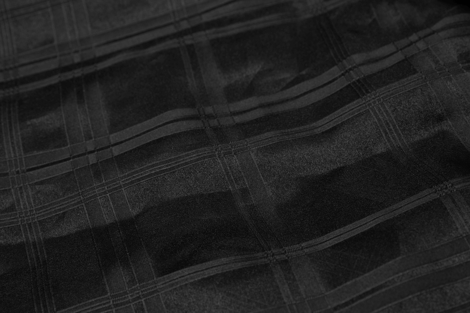 Close-up of a black checkered fabric showcasing a layered texture for a punk style skirt.