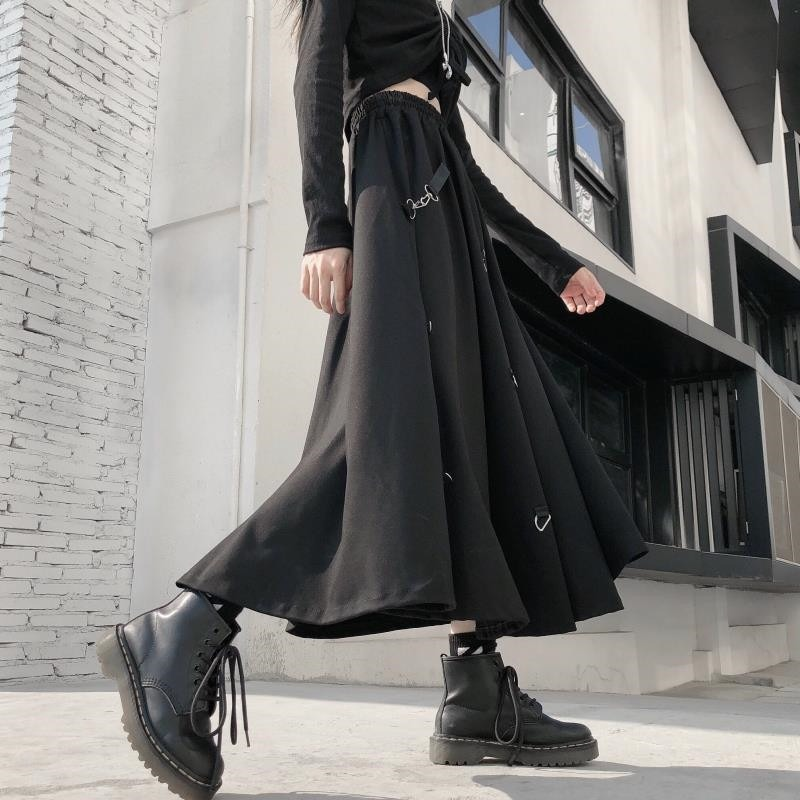 Punk style irregular long black skirt with buckles and elastic waist, paired with black combat boots.