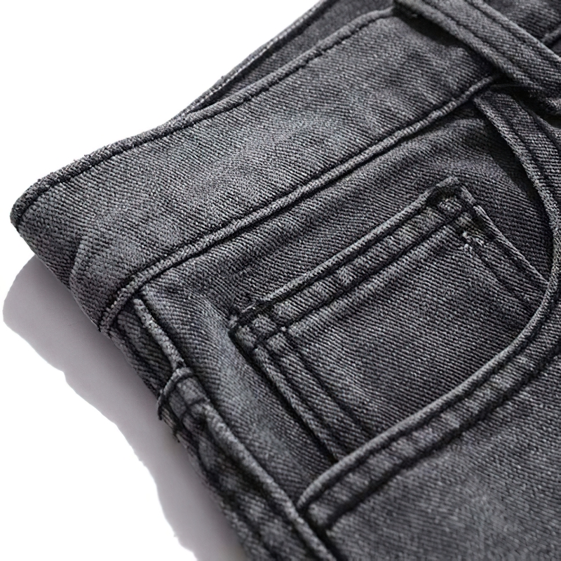 Close-up of punk style men's jeans with bone print, showcasing sturdy denim material and detailed pocket stitching.