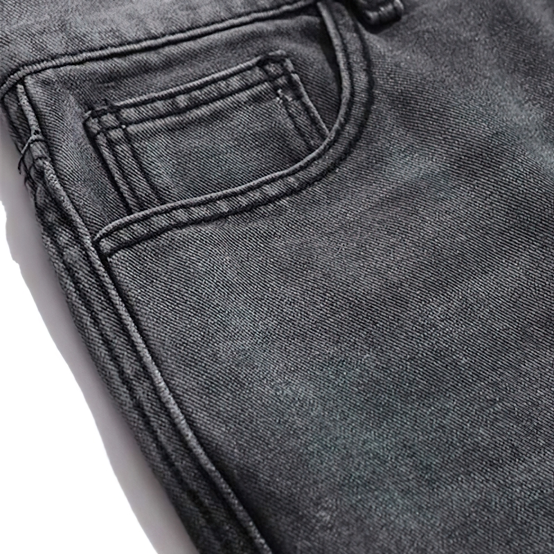 Close-up of men's punk style jeans with bone print, showcasing pocket detail and retro design in dark denim.