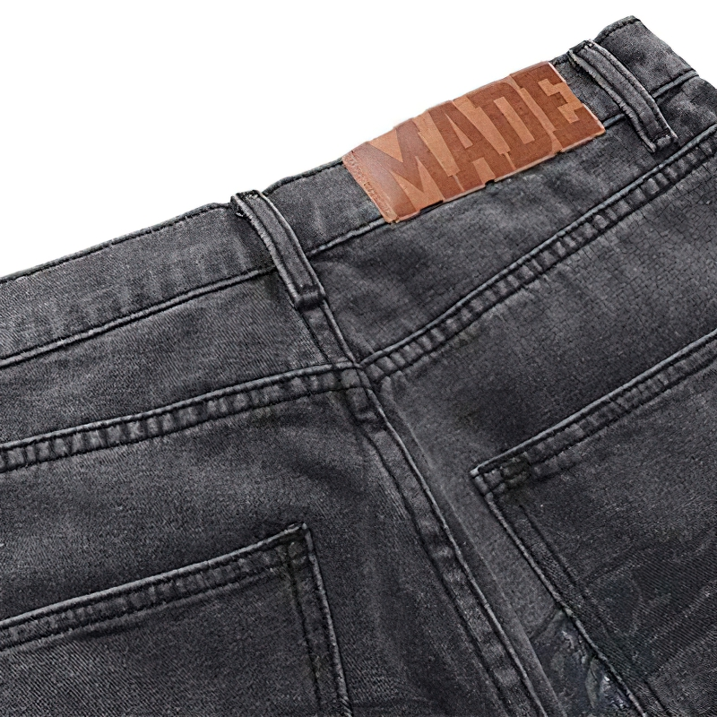 Punk style men's baggy denim jeans with bone print detailing and MADE label on the waistband.