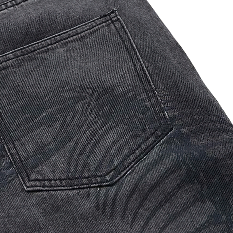 Punk style men's jeans with bone print close-up, featuring a black denim pocket.