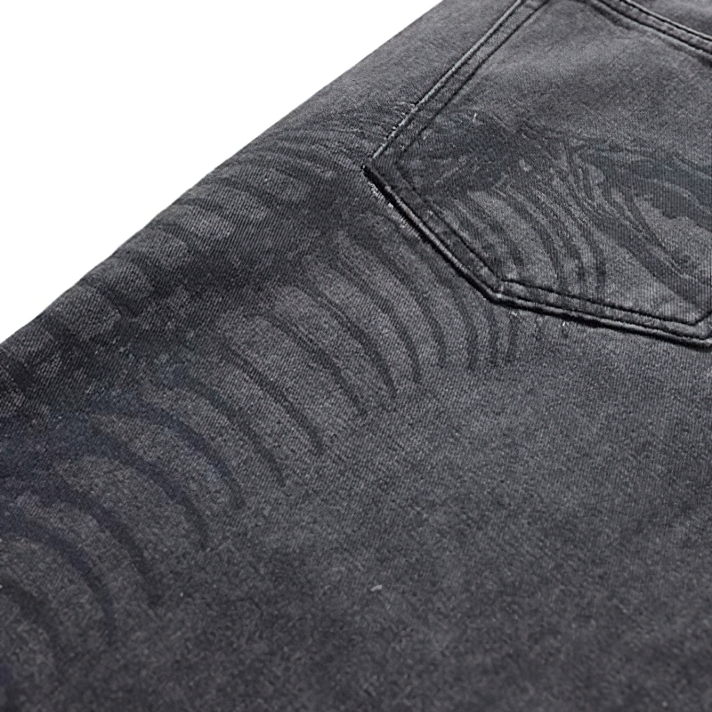 Punk style men's jeans with creative bone print, shown close-up of denim fabric and back pocket.