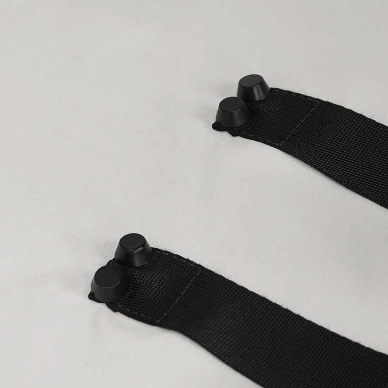 Close-up of stylish black nylon straps with buckles, featured on a punk style men's white long sleeve shirt.