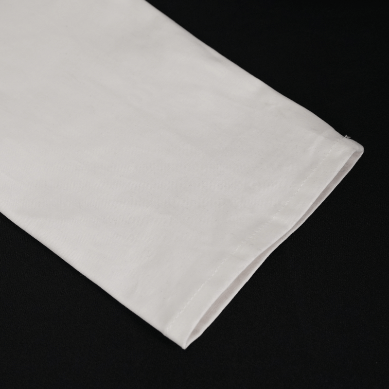 Close-up of a white long sleeve shirt sleeve, showcasing its clean finish and stylish cut, perfect for a punk style look.